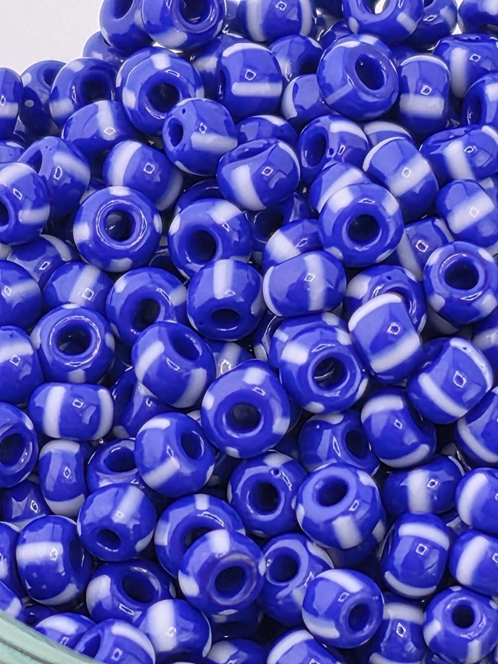 A close-up image of a pile of blue and white beads, with the focus on the individual beads and their arrangement.