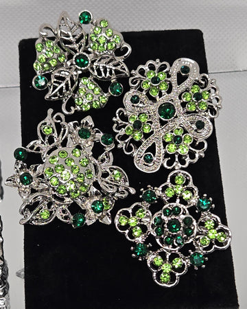 a collection of ornate brooches adorned with green gemstones.