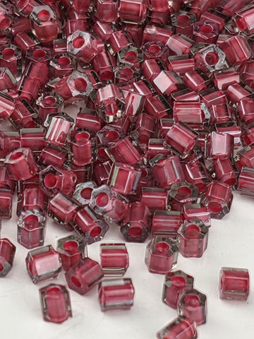 a close-up view of numerous red glass beads scattered across a surface.