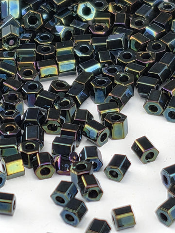 numerous small, black hexagonal beads scattered across a white background.