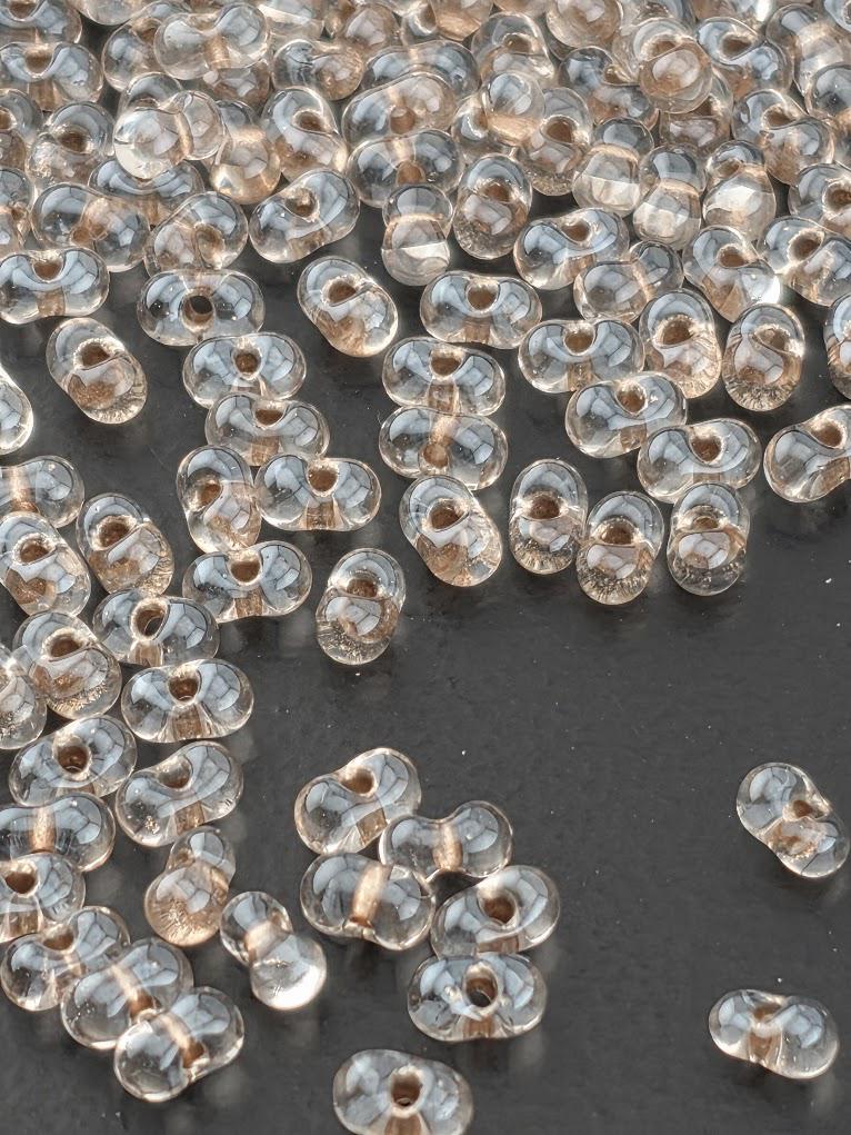 a collection of clear glass beads scattered on a dark surface.