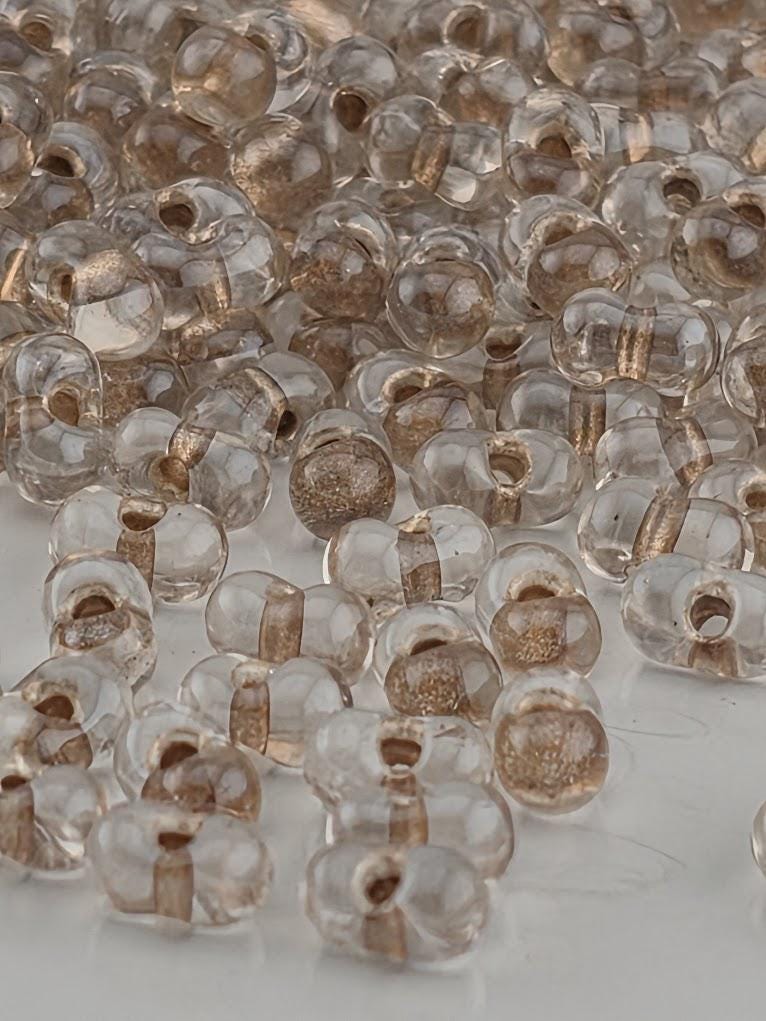 a collection of clear glass beads scattered on a white surface.
