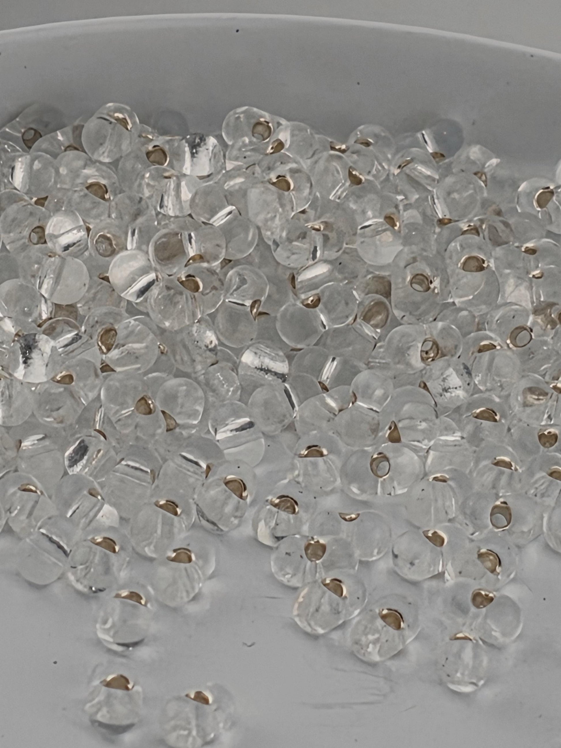 a close-up view of numerous clear glass beads scattered on a surface.