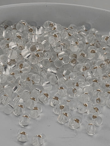 a close-up view of numerous clear glass beads scattered on a surface.