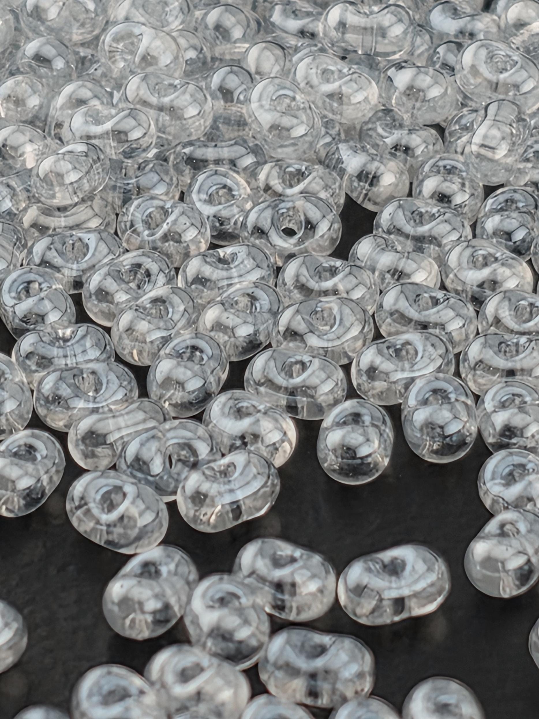 numerous transparent, clear beads scattered across a dark background.