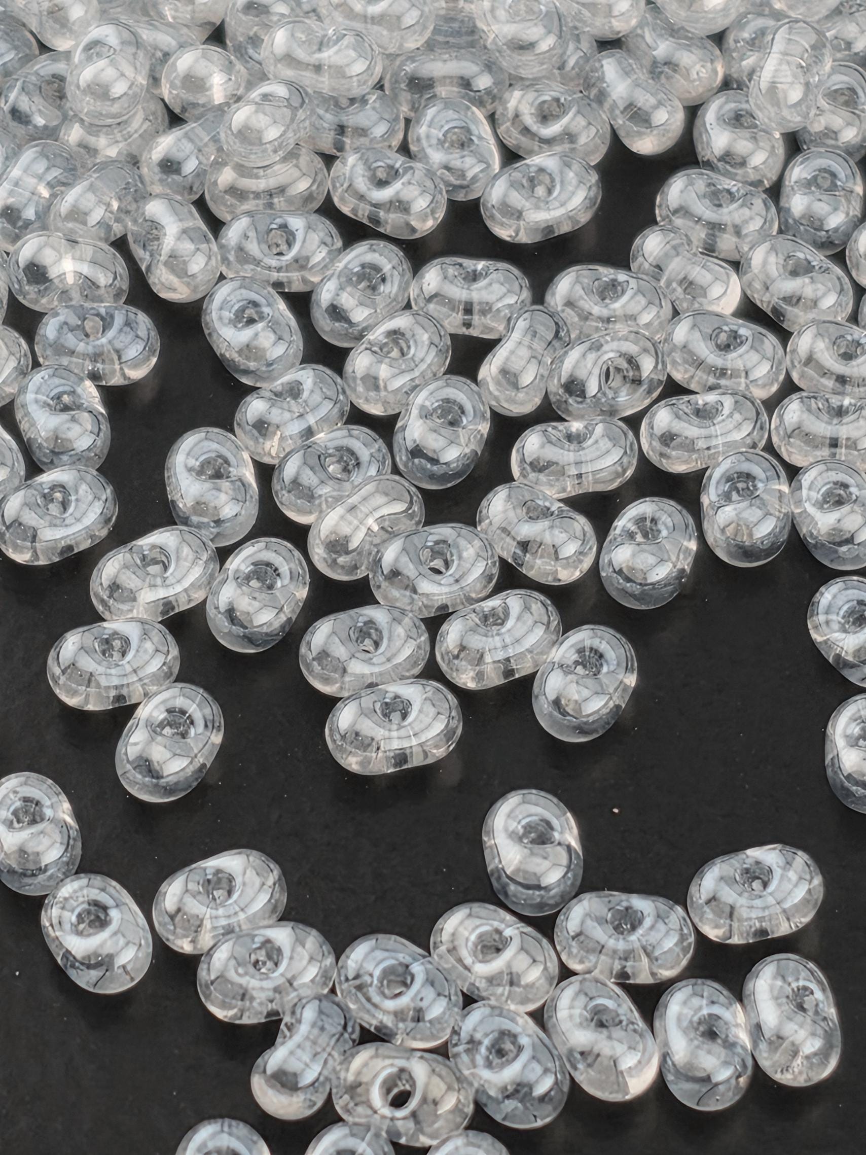 numerous transparent beads scattered across a dark background.