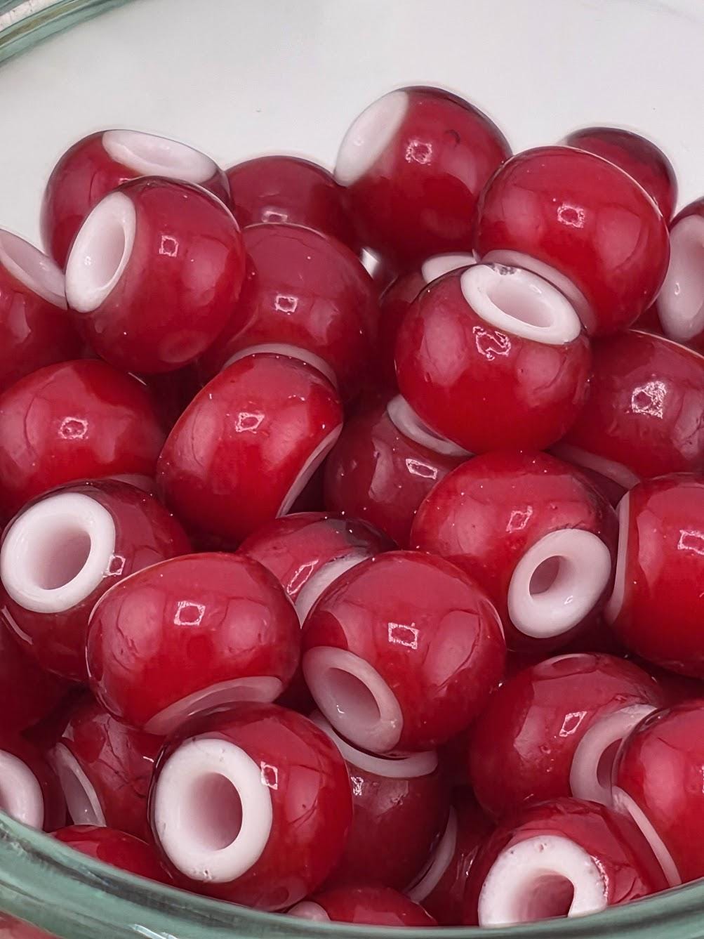A glass bowl filled with red and white beads, creating a visually appealing and colorful display.