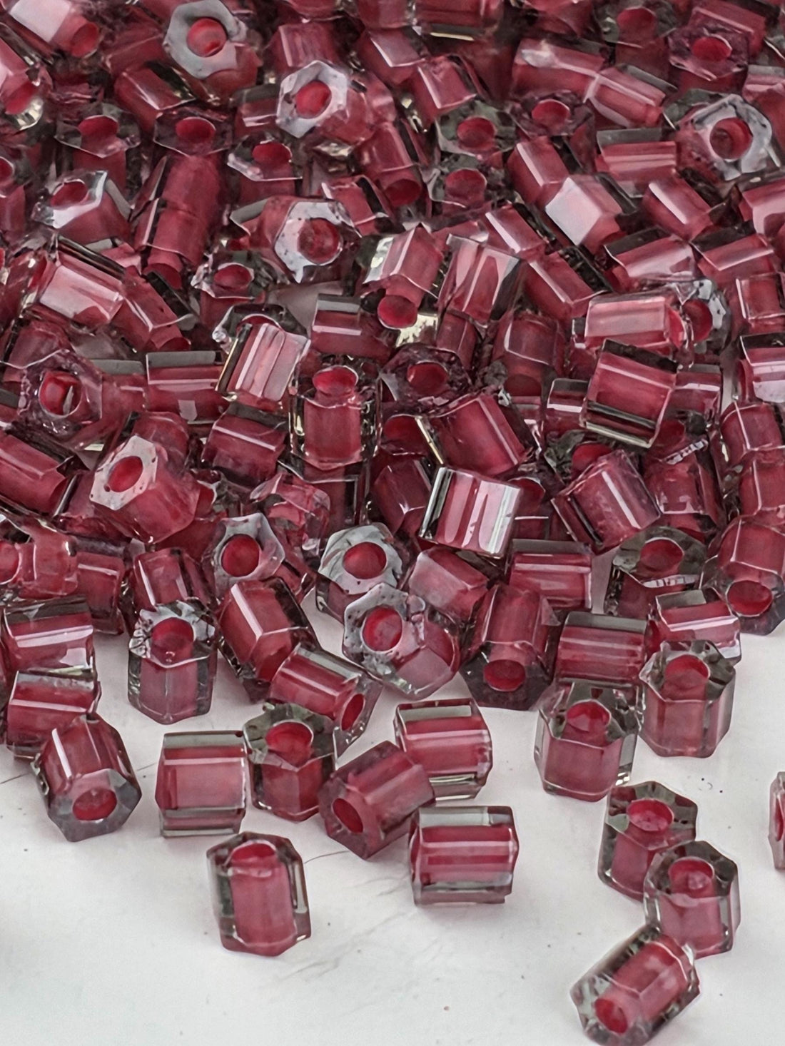 a close-up view of numerous red glass beads scattered across a surface.